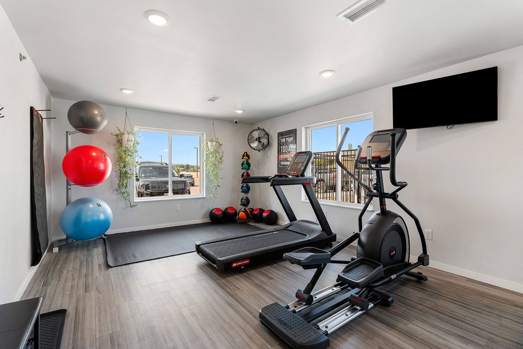 a gym with exercise equipment and a tv on the wall at Red Rock Apartments, South Dakota