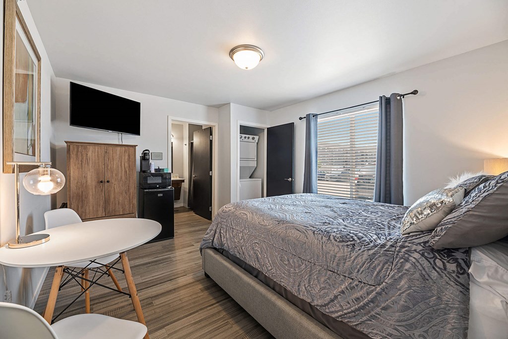 a bedroom with a bed and a small white table and chairs at Red Rock Apartments, Rapid City, South Dakota