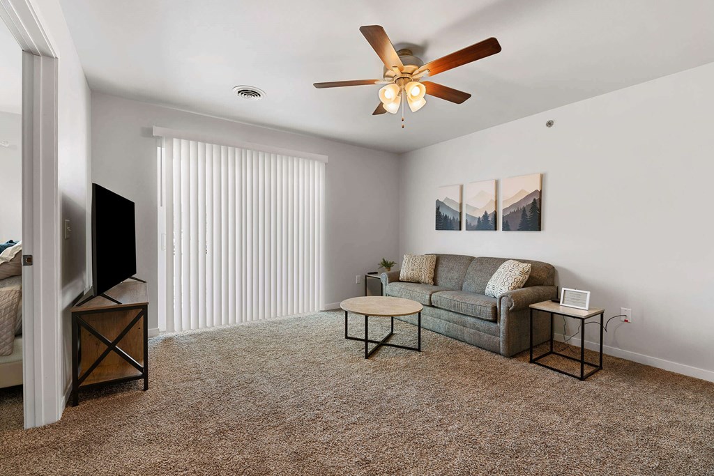 a living room with a couch and a ceiling fan at Red Rock Apartments, Rapid City, SD