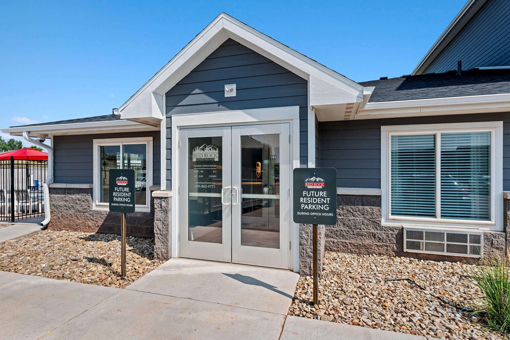 a blue house with two signs in front of it at Red Rock Apartments, Rapid City, 57702