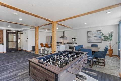 A modern kitchen with a foosball table in the middle.