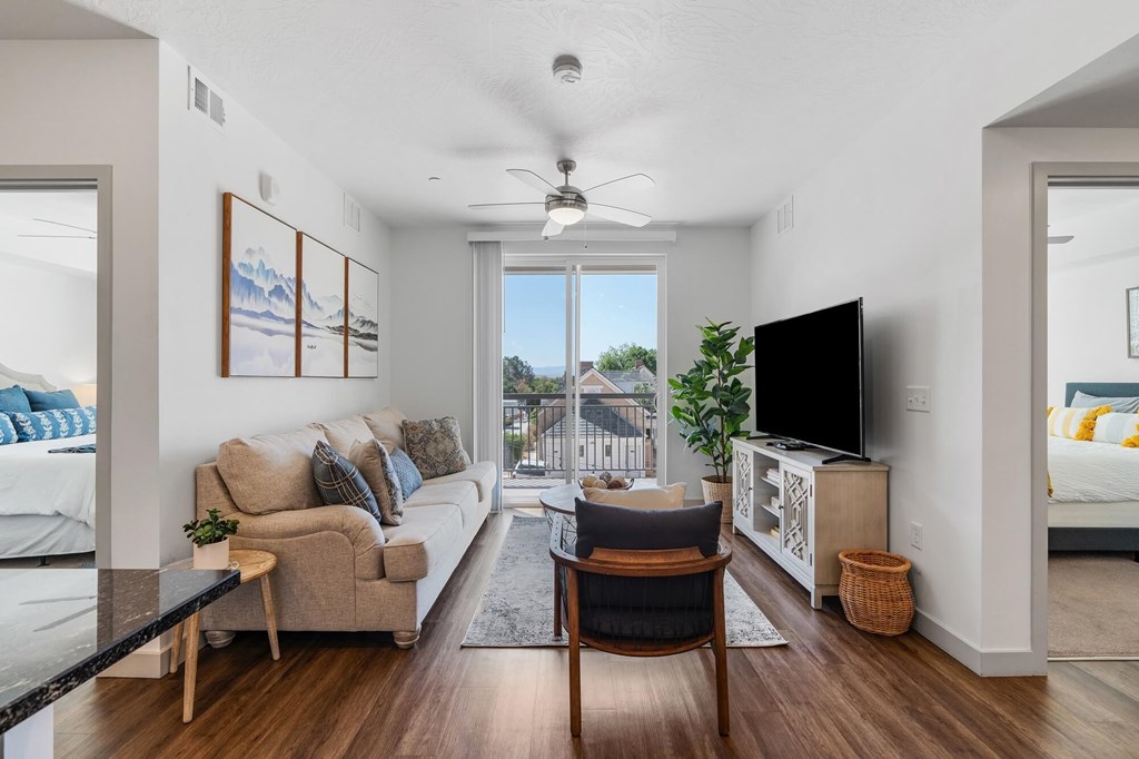 a living room with a couch and a chair and a tv a living room with a couch and a chair and a tv at City View St. George Apartments, St George, UT, 84770
