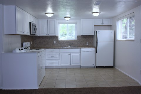 A kitchen with white cabinets and appliances.
