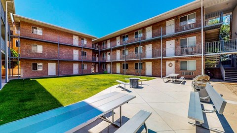 A sunny day at the apartment complex with blue skies and green grass.