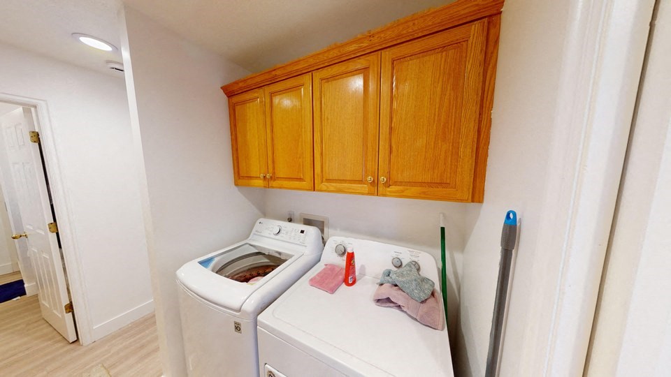 A white washing machine with a red and grey cloth on top of it.