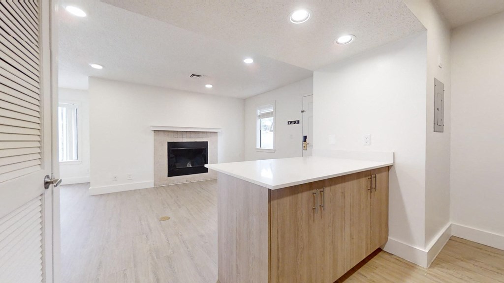 a kitchen with a white counter top and a fireplace