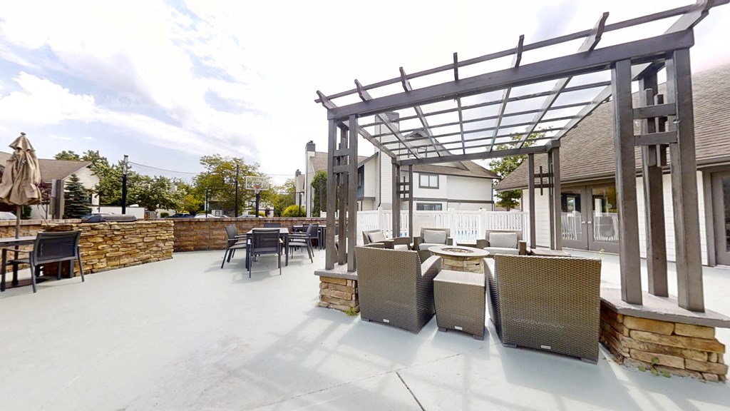 a patio with tables and chairs and a pergola