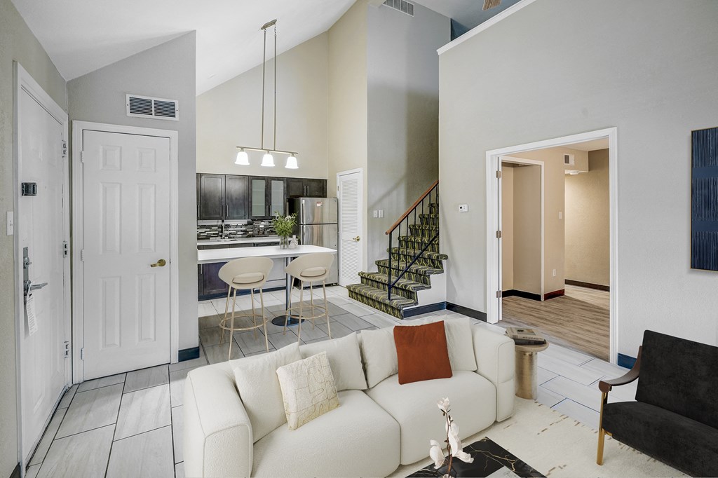 A living room with a white couch and a black chair.