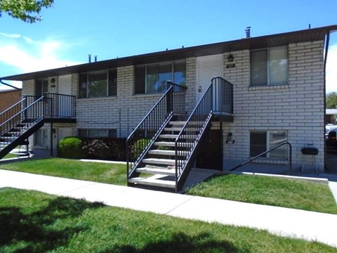 A small building with a black metal staircase.