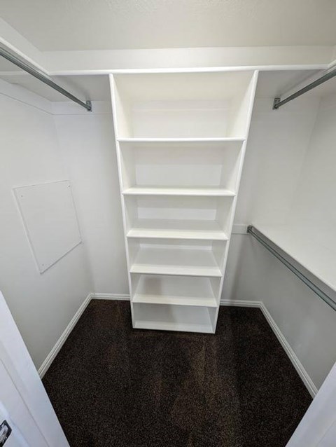 A white shelving unit in a small room.