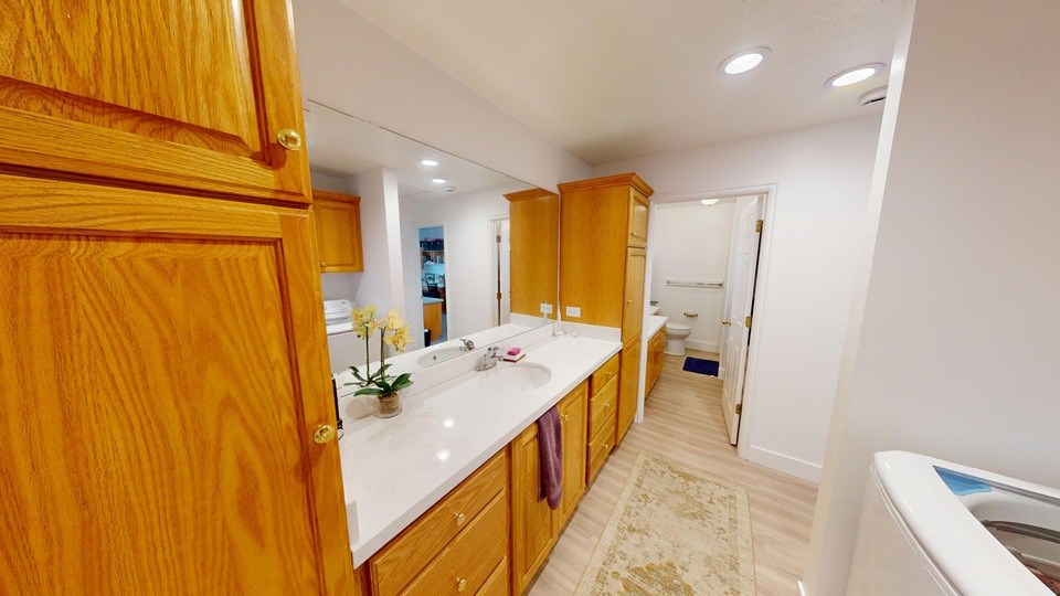 A bathroom with wooden cabinets and a white countertop.