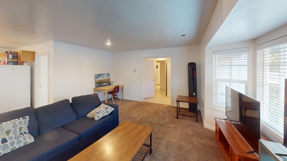 A living room with a blue couch and a wooden coffee table.