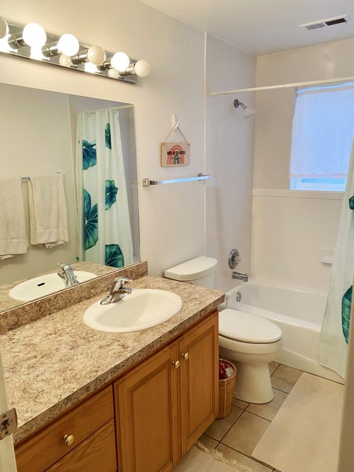 A bathroom with a sink, toilet, and shower.