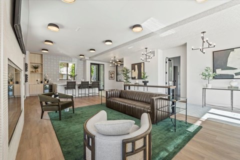 A modern living room with a green rug and brown leather sofa.
