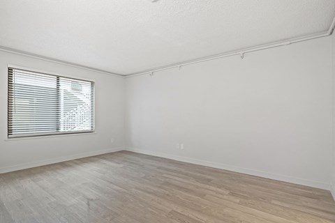 the living room of an empty home with white walls and a window at AVIA Lofts on Liberty Ridge Apartments, Jacksonville