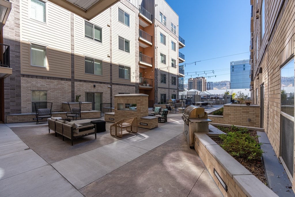 a patio with benches and tables in front of an apartment building at The Revival, Utah