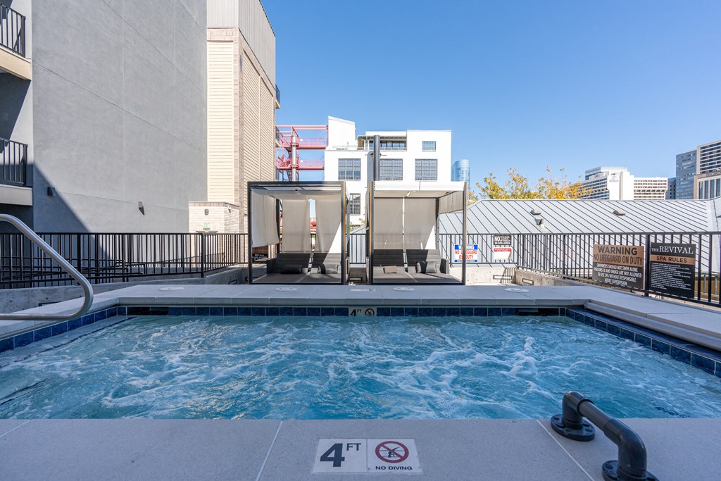 a swimming pool with a hot tub and a building in the background at The Revival, Utah, 84101