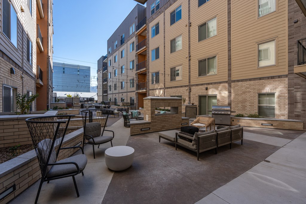 a communal patio with furniture and tables in front of an apartment building at The Revival, Utah