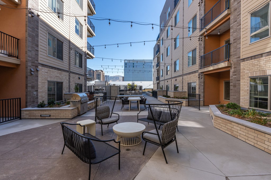 an outdoor patio area with tables and chairs and buildings at The Revival, Salt Lake City, 84101