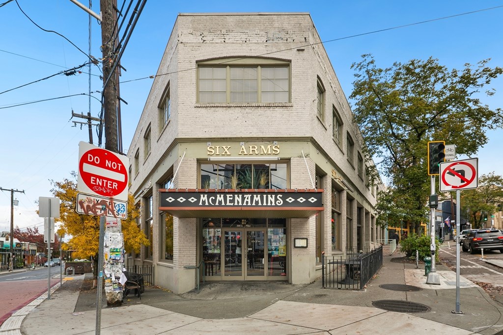 A building with a sign that says "Six Arms" and "McMenamins" on it.