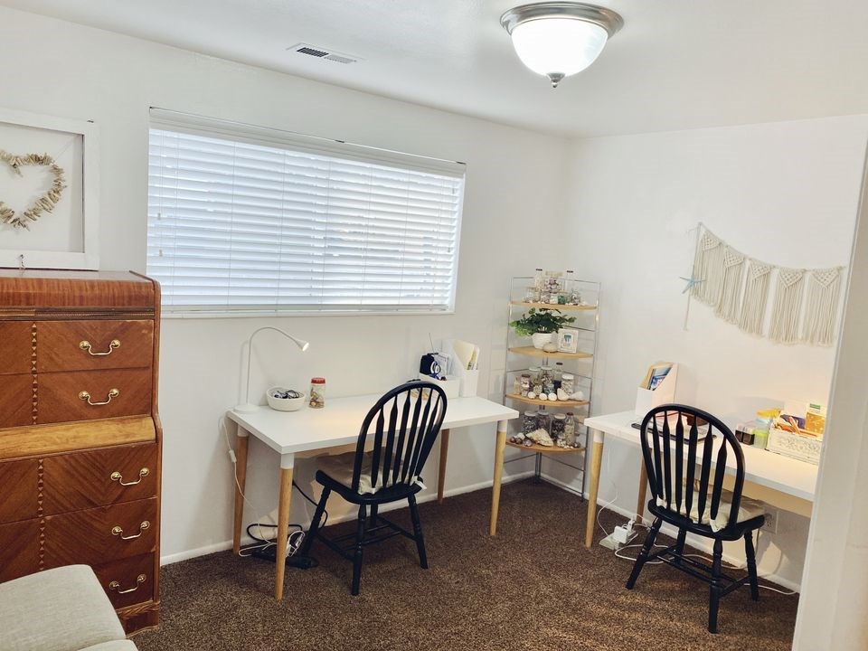 A room with a desk, chair, and a cabinet.