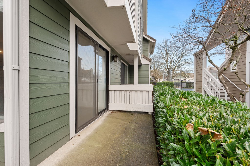 A green house with a white fence and a glass door. at AVIA Lofts on Parkway Apartments, Vancouver