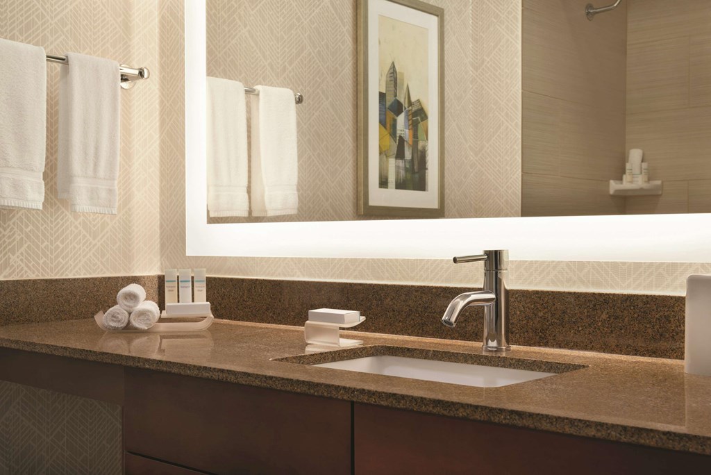 A bathroom with a brown counter top and a silver faucet.at AVIA on Pike Street, Seattle