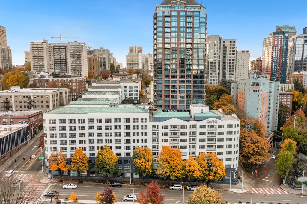 A cityscape with a large building in the foreground and other buildings in the background.