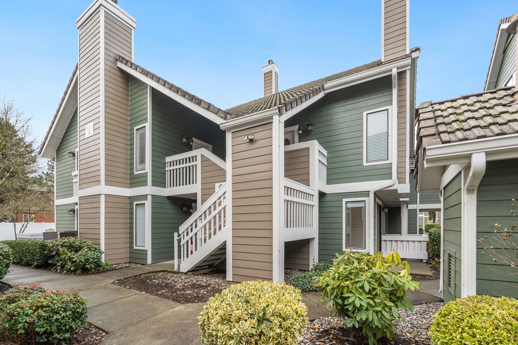 A green and beige two story house with a front yard. at AVIA Lofts on Parkway Apartments, Vancouver, Washington