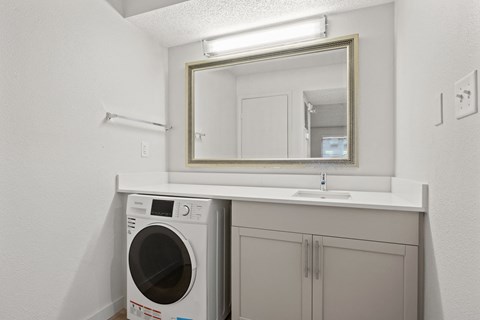 a white laundry room with a sink and a washing machine at AVIA Lofts on Liberty Ridge Apartments, Jacksonville, Florida