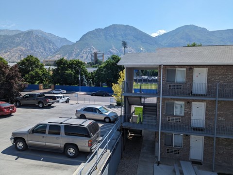 A parking lot with cars and a mountain in the background.