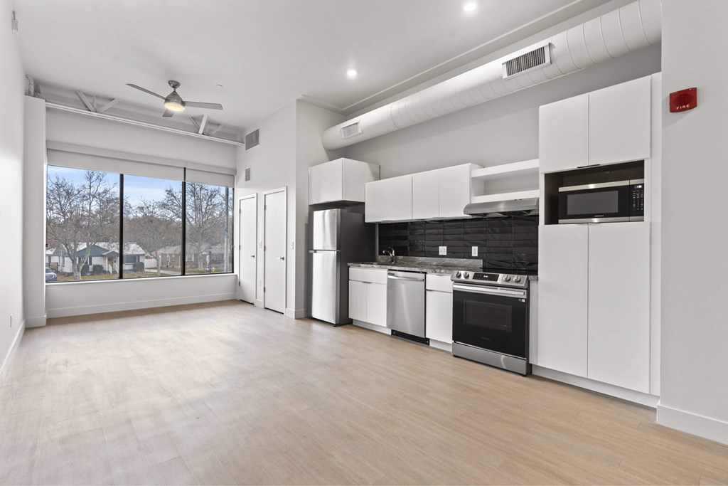 A spacious kitchen with white cabinets and stainless steel appliances.