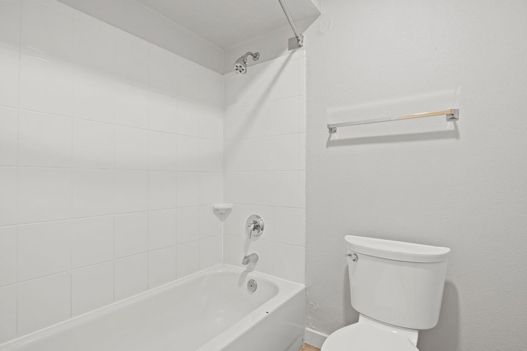 a white bathroom with a tub and a toilet