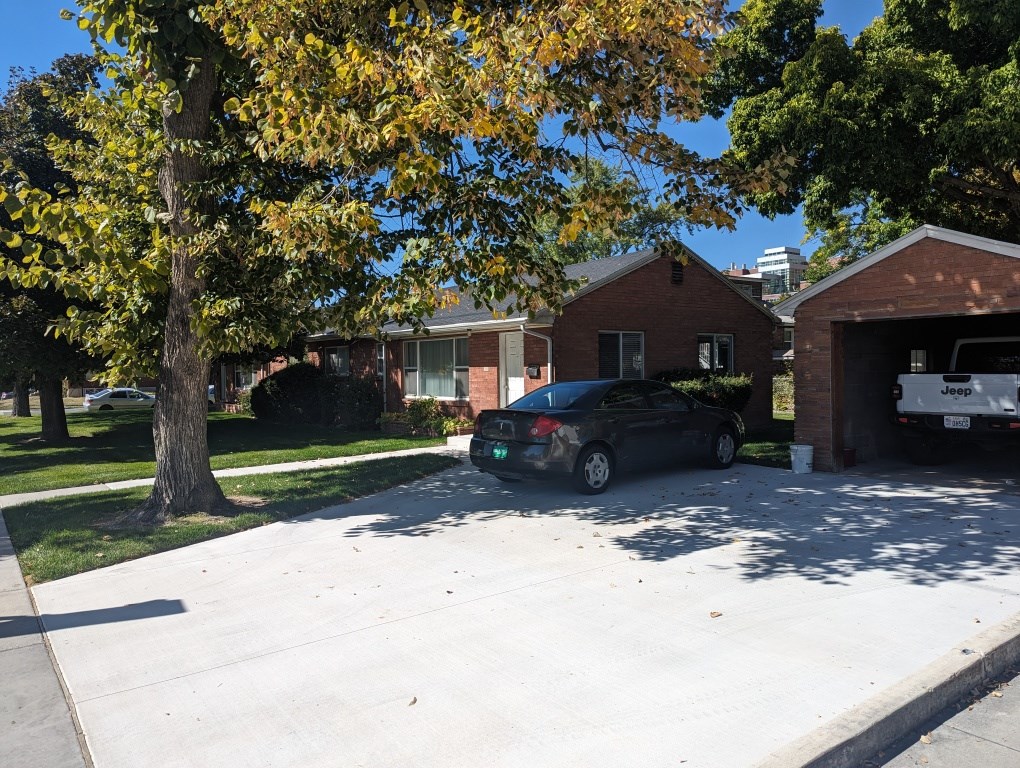 A black car is parked in a driveway.