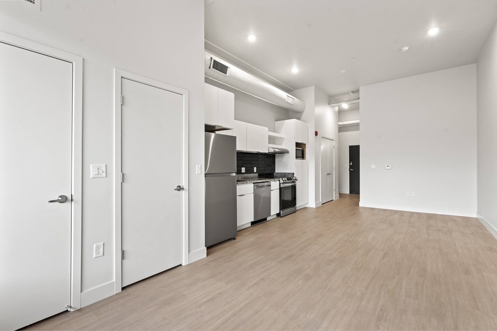 A kitchen with white appliances and cabinets is shown. at Brickside Heights, Millcreek, Utah