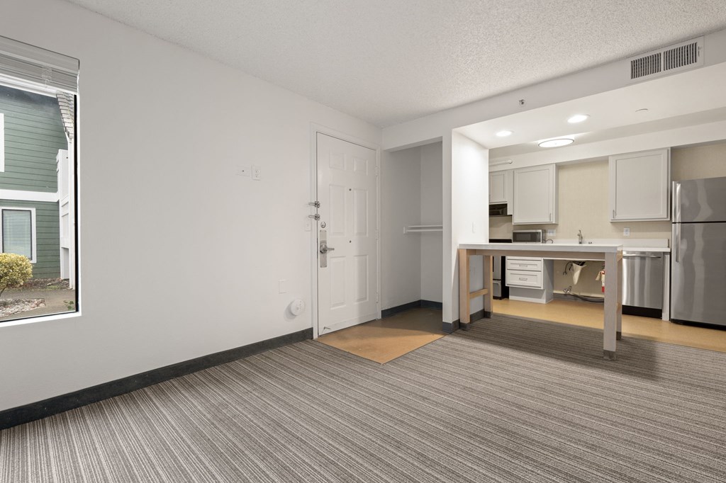 A kitchen area with a table and chairs in the middle of the room. at AVIA Lofts on Parkway Apartments, Vancouver, WA, 98662