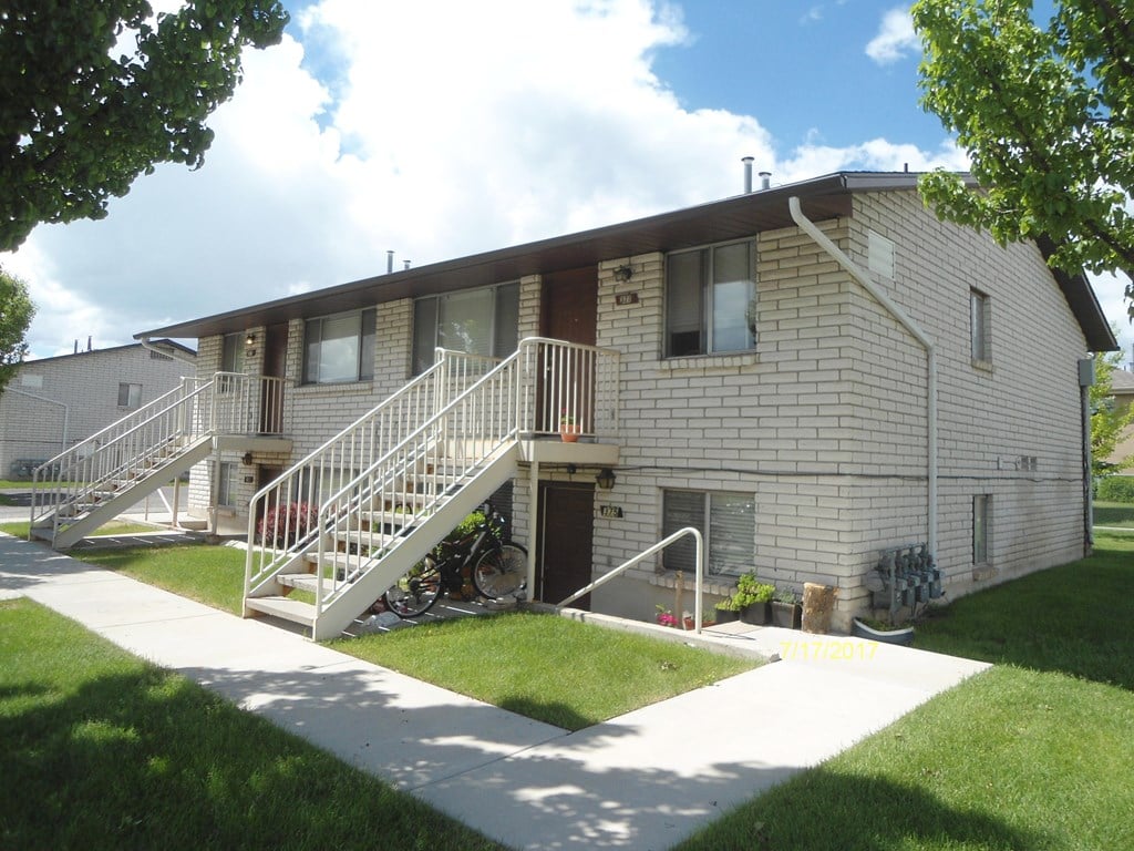 A building with a white staircase and a bicycle in front of it.