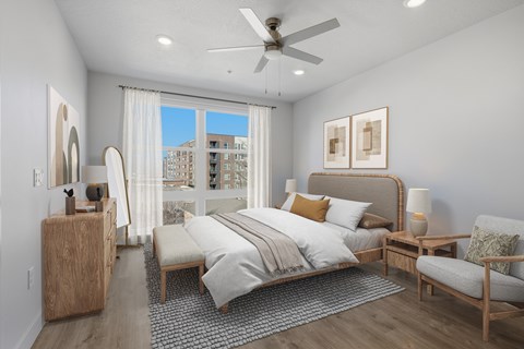 Bedroom with neutral decor and patio access at Brickside Heights Apartments, Millcreek, UT
