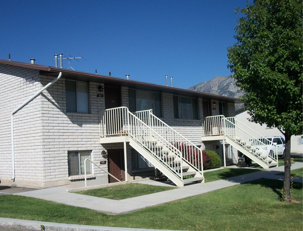 A building with a staircase leading to the front door.