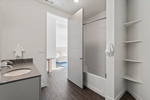 A bathroom with a sink, mirror, and towel rack.