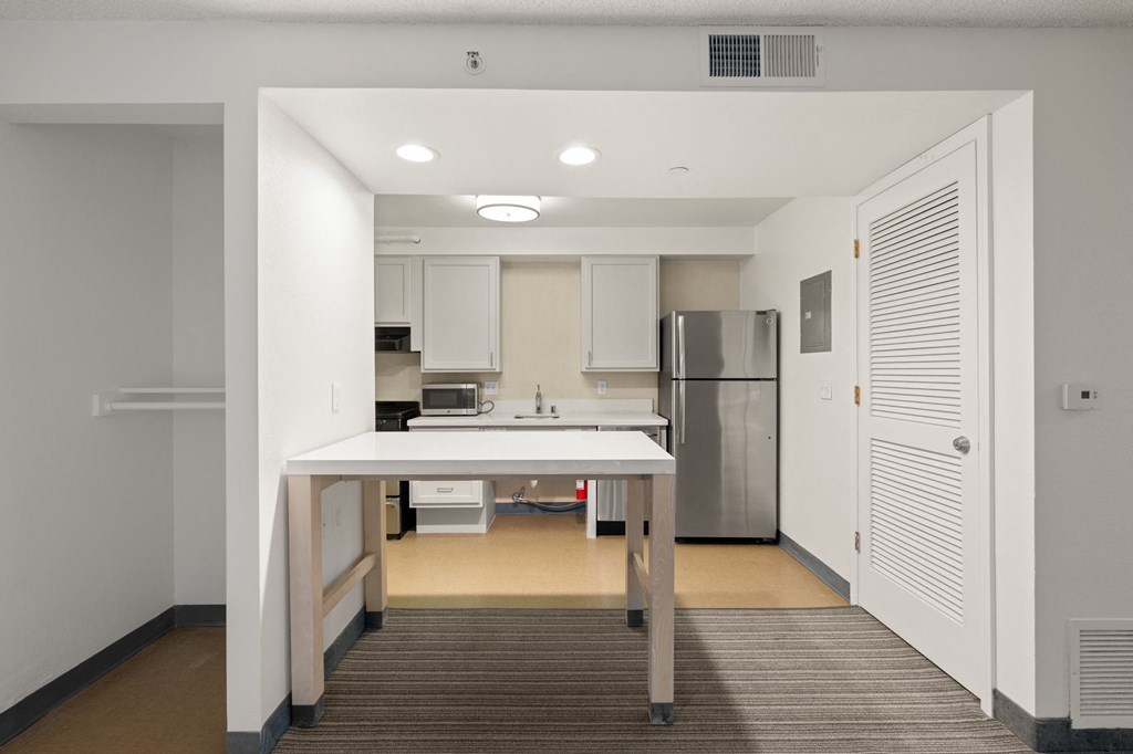 A kitchen with white cabinets and a refrigerator. at AVIA Lofts on Parkway Apartments, Vancouver, WA