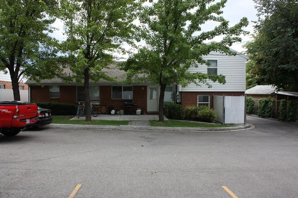 A red truck is parked in a parking lot in front of a building.