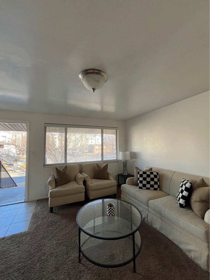 A living room with a glass table and two couches.