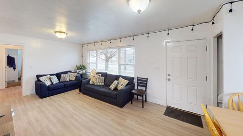 A living room with a black couch and a wooden table.