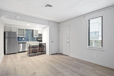 the living room and kitchen of an apartment with a crib and a refrigerator at AVIA Lofts on Liberty Ridge Apartments, Jacksonville, FL, 32256