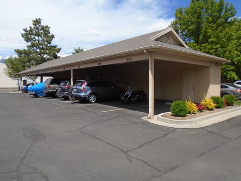 A parking lot with a building and cars parked.