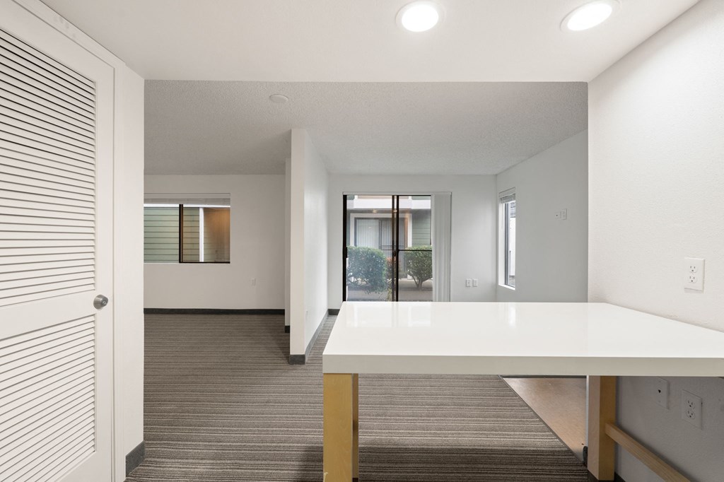 A white table is in a room with a carpeted floor. at AVIA Lofts on Parkway Apartments, Vancouver, WA, 98662q