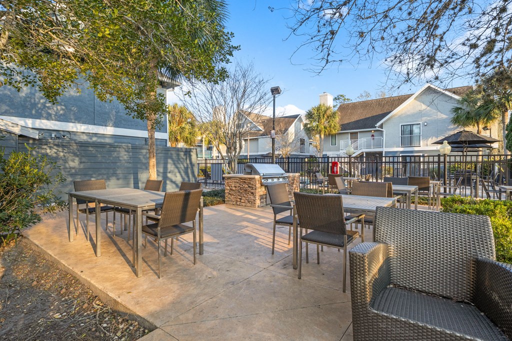 a patio with tables and chairs and a fence