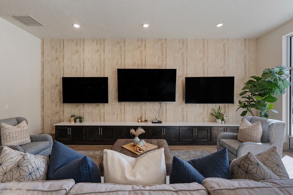 a living room with couches and chairs and televisions on the wall at 200 City View, Provo, Utah
