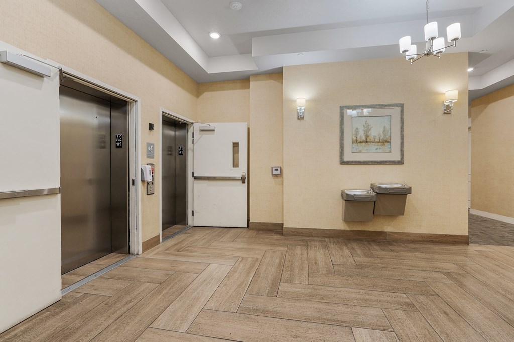 a lobby with two elevators and two urinals and a hallway with doors at 200 City View, Provo, UT, 84601